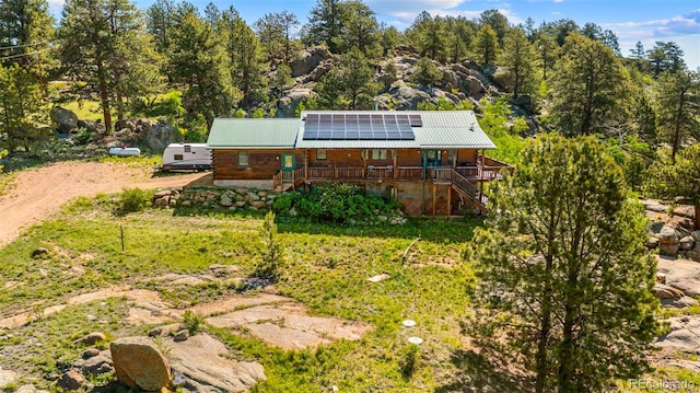 3980 County Rd 71, Guffey, CO 80820 - rear view of property featuring stairs, covered porch, roof mounted solar panels, and a metal roof