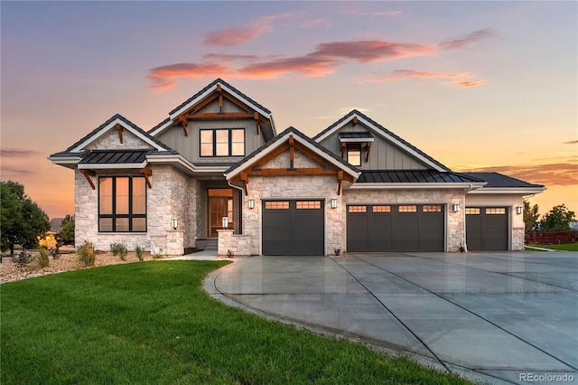 view of front of house with a front yard, metal roof, driveway, an attached garage, and a standing seam roof