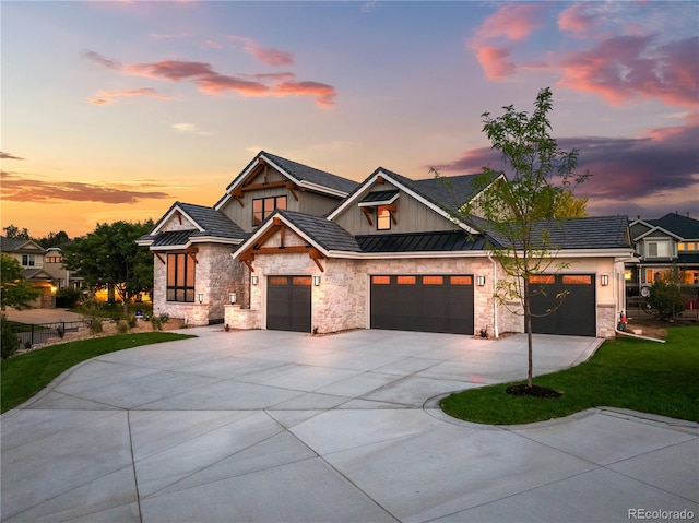 view of front of property with a standing seam roof, stone siding, driveway, and metal roof