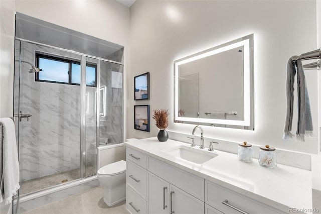 bathroom with a shower with door, vanity, and toilet