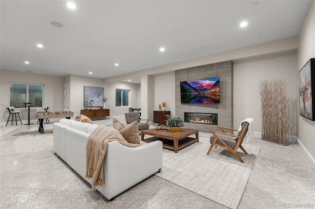 living room with a tile fireplace and light colored carpet