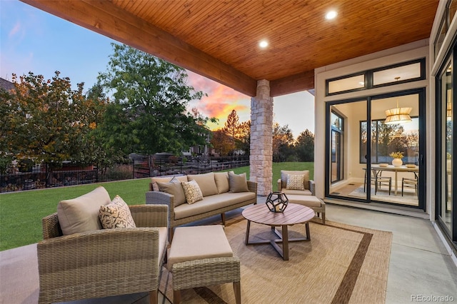 patio terrace at dusk with a lawn and an outdoor living space