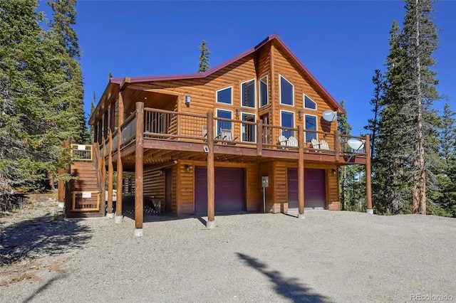 view of front facade with driveway, a garage, a deck, and log veneer siding