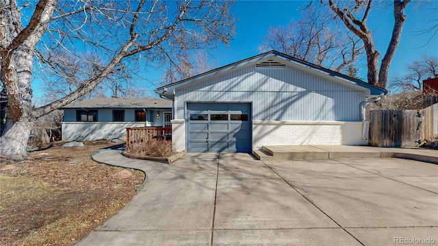 view of front facade with a garage, brick siding, and fence