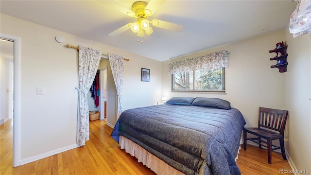 bedroom with a ceiling fan, light wood-style flooring, and baseboards