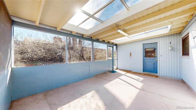 unfurnished sunroom featuring a skylight and beam ceiling