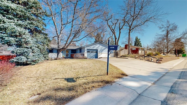 view of front facade featuring a garage, concrete driveway, and a front yard