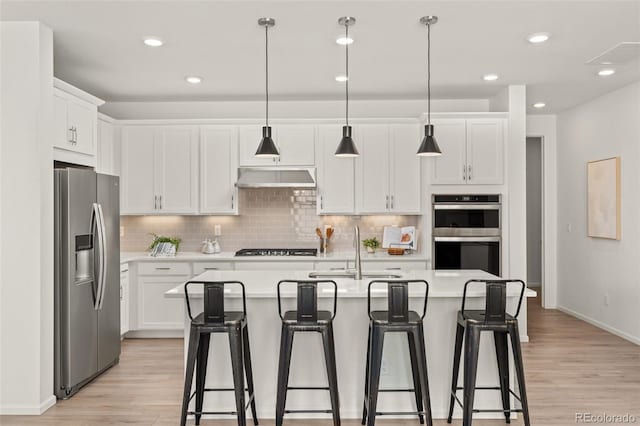 kitchen with sink, white cabinetry, a kitchen island with sink, and appliances with stainless steel finishes