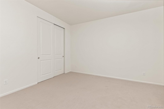 unfurnished bedroom featuring a closet and light carpet