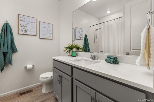 bathroom featuring toilet, a shower with shower curtain, vanity, and hardwood / wood-style floors