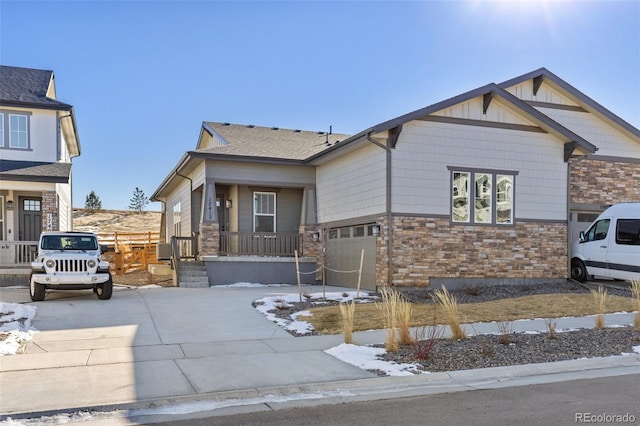 view of front of house featuring a garage, driveway, and stone siding