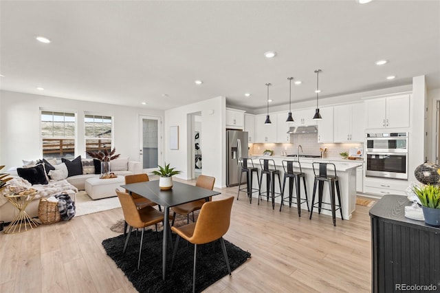 dining space featuring recessed lighting and light wood-style floors