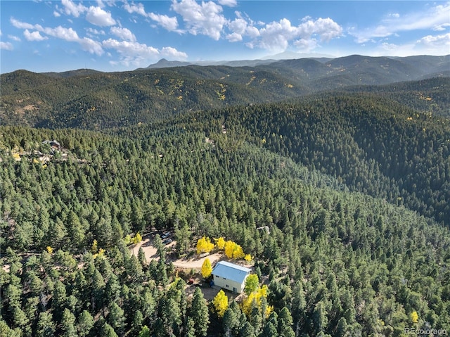 view of mountain backdrop featuring a heavily wooded area
