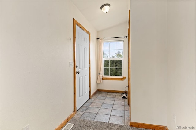 entryway featuring baseboards and lofted ceiling