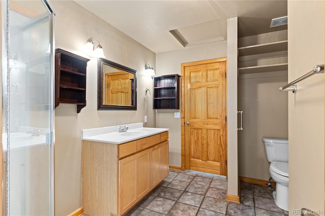 full bathroom featuring toilet, baseboards, vanity, and stone finish floors