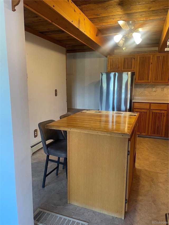 60 Pawnee Path, Lake George, CO 80827 - kitchen with freestanding refrigerator, ceiling fan, wood ceiling, brown cabinetry, and a center island