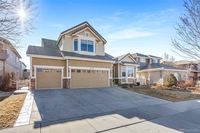 craftsman house with driveway, stone siding, and a tiled roof