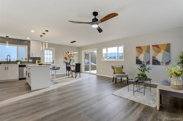 interior space with recessed lighting, ceiling fan with notable chandelier, light wood-type flooring, and baseboards