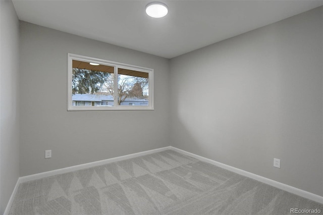 carpeted spare room featuring baseboards