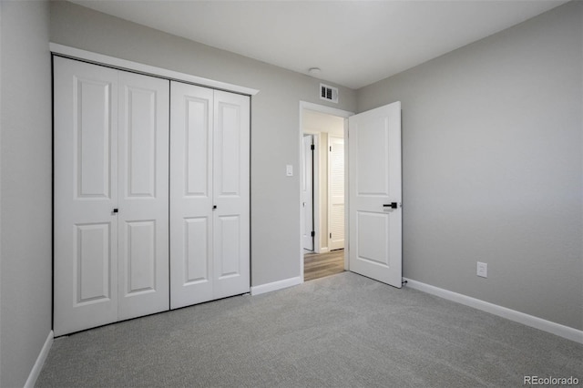 unfurnished bedroom with a closet, baseboards, visible vents, and carpet floors