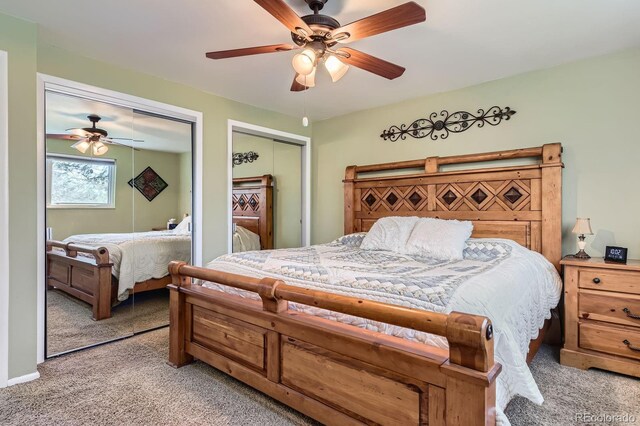 carpeted bedroom featuring two closets and ceiling fan