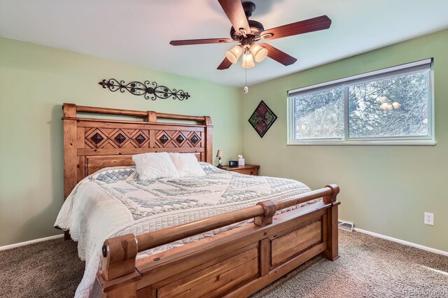 bedroom with a ceiling fan, baseboards, visible vents, and carpet