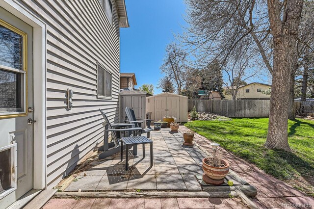 view of patio with a fenced backyard, an outdoor structure, and a shed