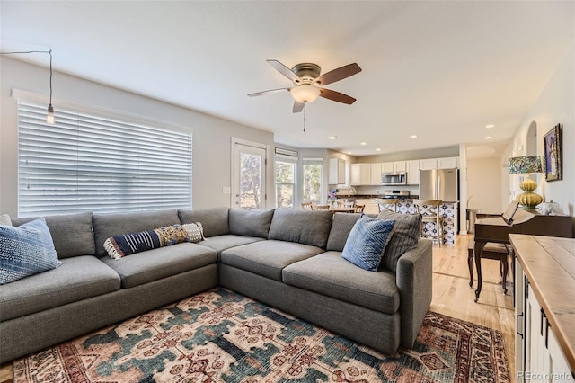 living room with ceiling fan and light hardwood / wood-style floors