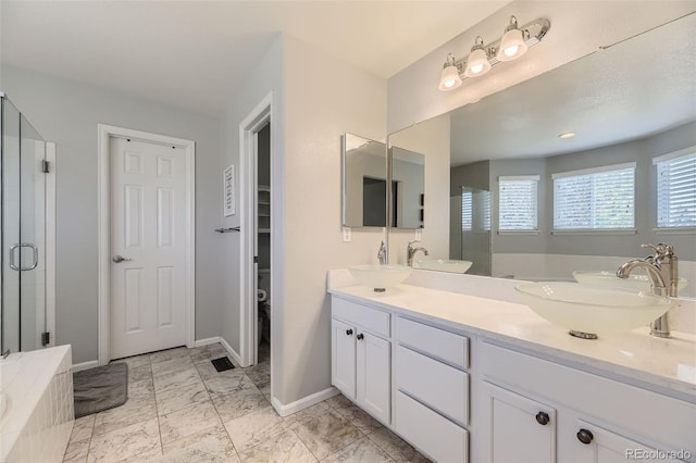 bathroom with vanity and shower with separate bathtub