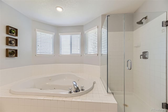 bathroom with separate shower and tub and a textured ceiling