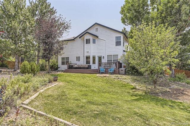 rear view of house featuring a yard and a deck