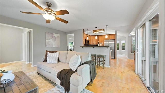 5150 Morning Glory Pl, Highlands Ranch, CO 80130 - living room featuring healthy amount of natural light, a ceiling fan, and light wood-style flooring