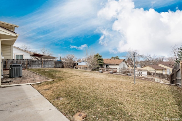 view of yard with a residential view, central AC, and a fenced backyard