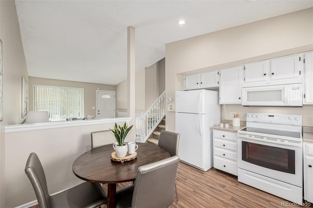 kitchen with light countertops, white appliances, light wood-style flooring, and white cabinetry