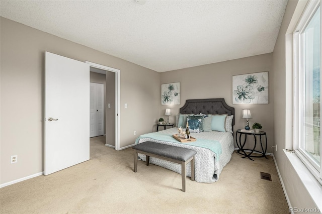 bedroom featuring carpet floors, multiple windows, visible vents, and baseboards