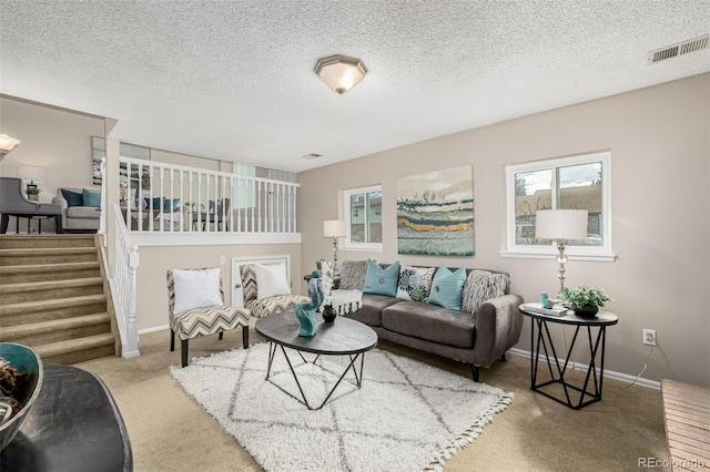 living area featuring baseboards, visible vents, stairway, and carpet flooring