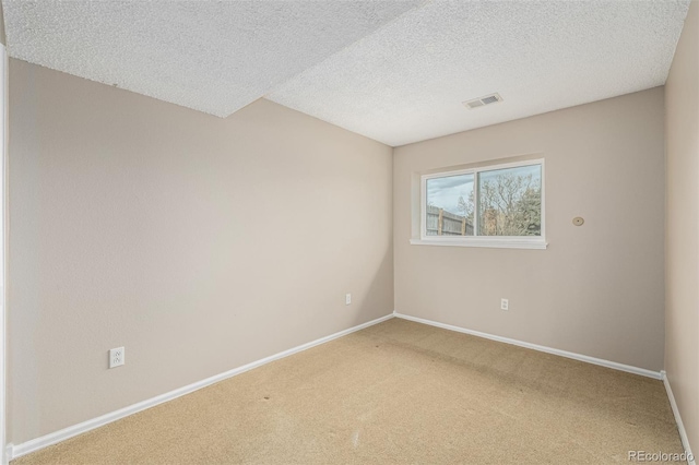 unfurnished room featuring carpet, a textured ceiling, visible vents, and baseboards