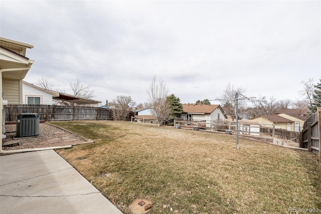 view of yard featuring a fenced backyard, a residential view, and central AC unit