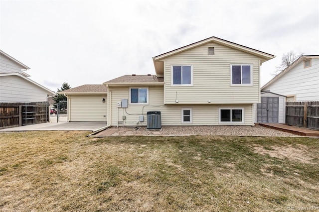 rear view of property featuring an outbuilding, a patio, a lawn, a storage shed, and fence