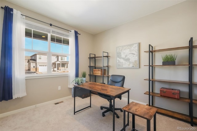 home office with light colored carpet, visible vents, and baseboards