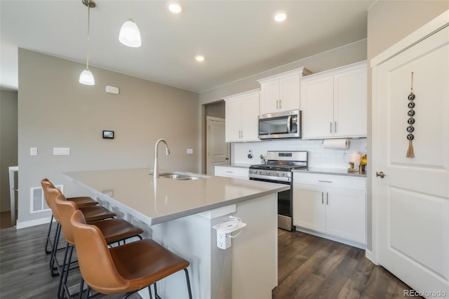 kitchen featuring an island with sink, white cabinetry, appliances with stainless steel finishes, and a sink