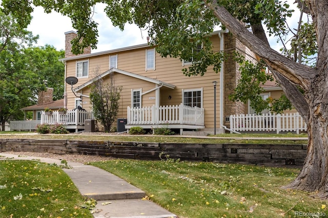 8463 Everett Way Unit B, Arvada, CO 80005 - view of front of property with a chimney, a front yard, and a wooden deck
