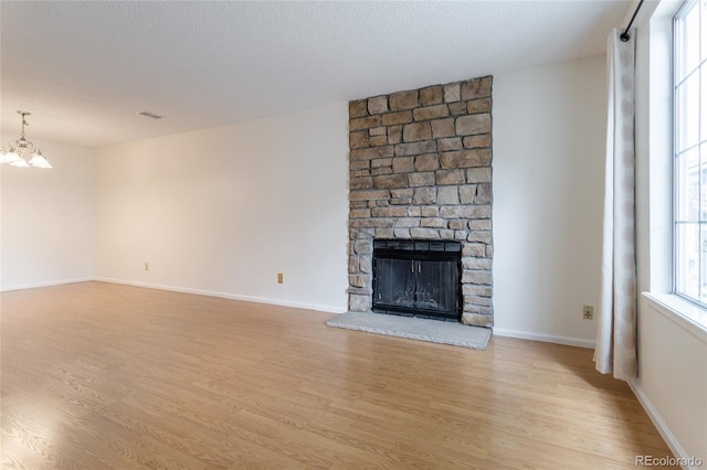 8463 Everett Way Unit B, Arvada, CO 80005 - unfurnished living room with light wood-type flooring, a chandelier, and a large fireplace