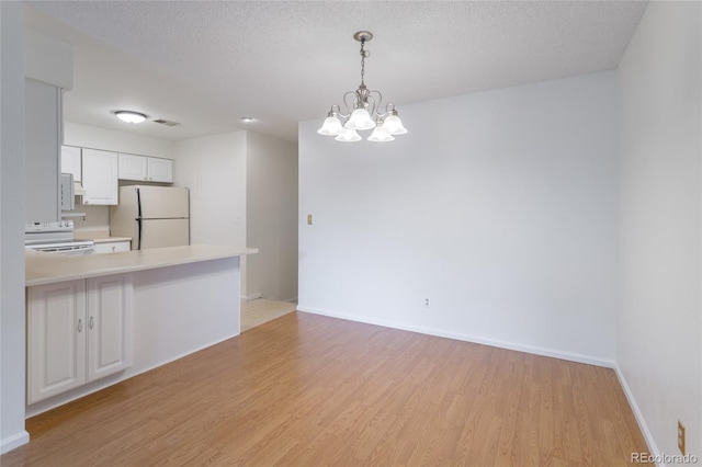 8463 Everett Way Unit B, Arvada, CO 80005 - kitchen with white appliances, light wood-style flooring, pendant lighting, white cabinetry, and light countertops