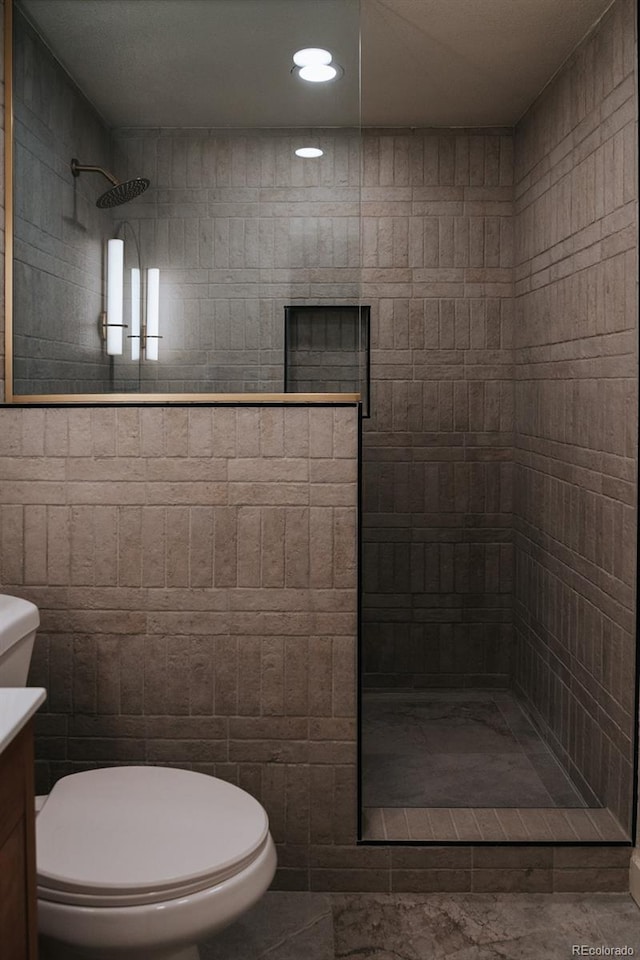 30938 Niakwa Rd, Evergreen, CO 80439 - full bath with tiled shower, vanity, tile walls, and recessed lighting
