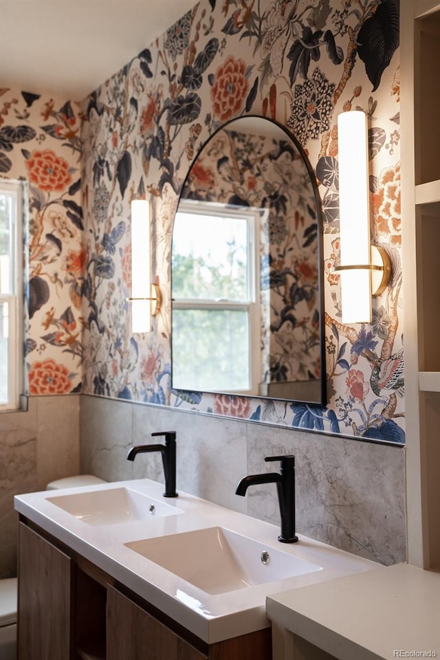 30938 Niakwa Rd, Evergreen, CO 80439 - bathroom with tile walls, wallpapered walls, double vanity, plenty of natural light, and a wainscoted wall