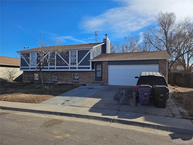 view of front of home featuring a garage, driveway, a chimney, and brick siding