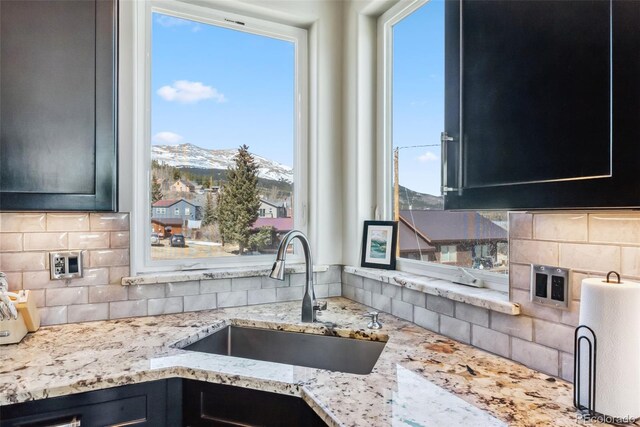 255 Flannigan Cir, Alma, CO 80420 - kitchen featuring backsplash, light stone countertops, a sink, a mountain view, and dark cabinets
