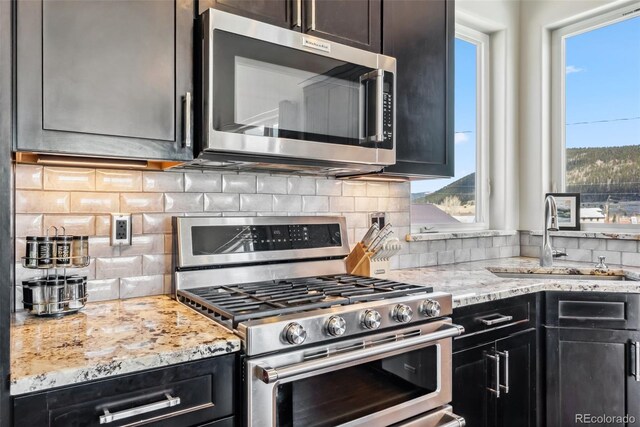 255 Flannigan Cir, Alma, CO 80420 - kitchen featuring a sink, appliances with stainless steel finishes, decorative backsplash, and light stone countertops