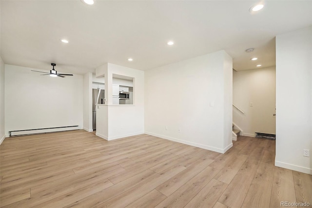 unfurnished living room featuring a baseboard heating unit, ceiling fan, and light hardwood / wood-style flooring